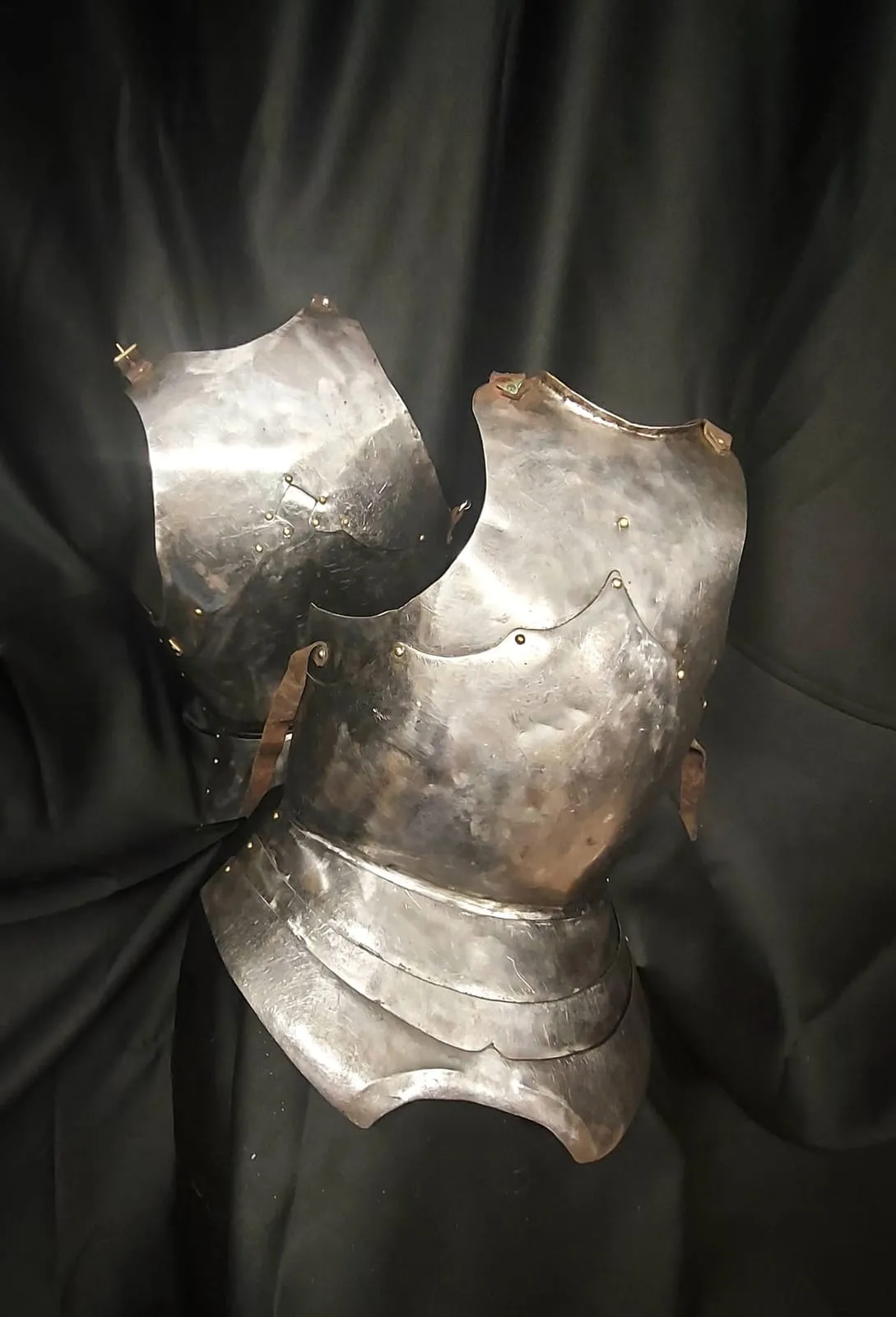 Steel breastplate photographed on a black background