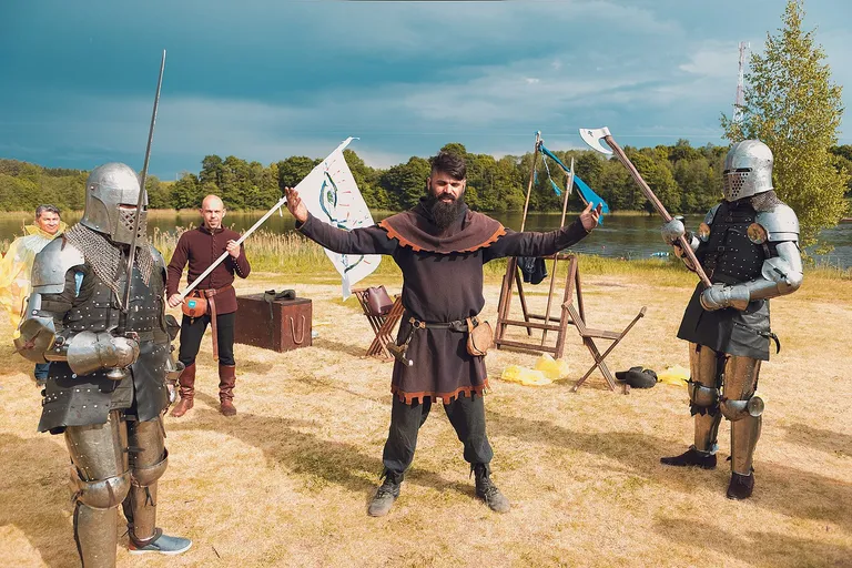Armoured knights with axes and a banner at a lakeside warfare arena